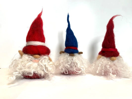 Three gnome figurines with red and blue hats on a white background